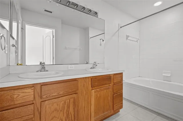 a bathroom with a tub sink and mirror