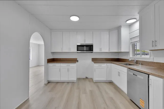 a kitchen with granite countertop white cabinets and white appliances