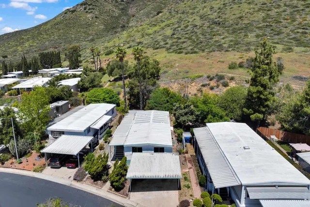 an aerial view of a house with yard and mountain view in back