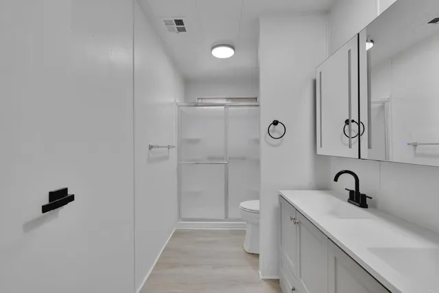 a bathroom with a sink a toilet and shower