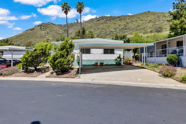 a front view of a house with a yard and potted plants