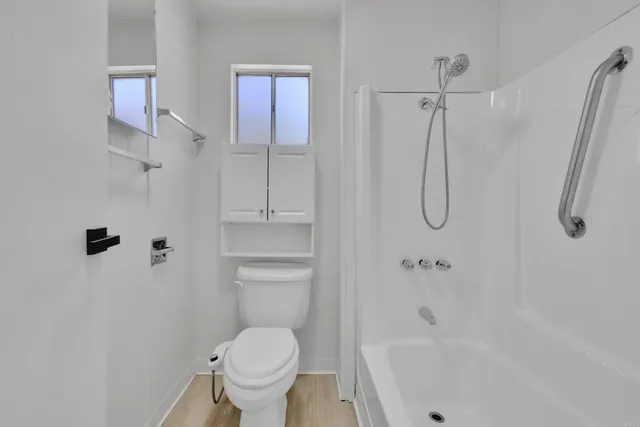 a spacious bathroom with a granite countertop sink a toilet and a bathtub