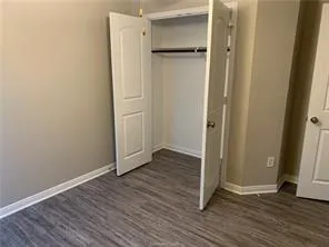 an empty room with wooden floor and entrance