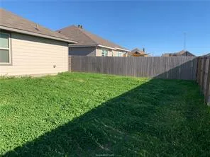 a view of a backyard with wooden fence