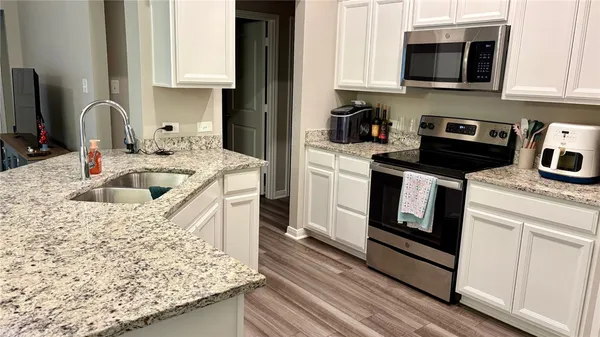 a kitchen with stainless steel appliances granite countertop a sink stove and microwave