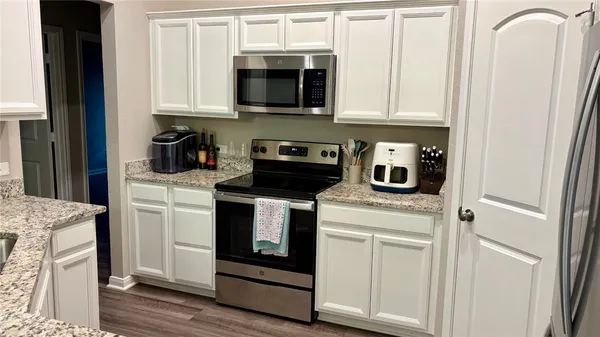 a kitchen with white cabinets and white appliances