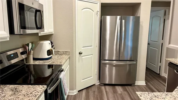 a kitchen with stainless steel appliances granite countertop a refrigerator and a stove top oven