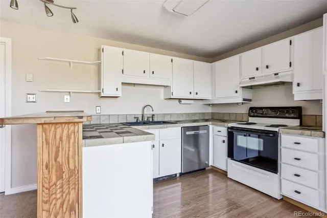 a kitchen with granite countertop white cabinets and white appliances