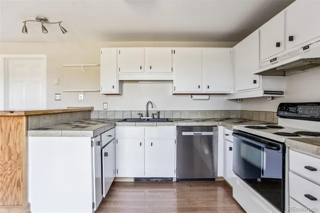 a kitchen with white cabinets and a stove