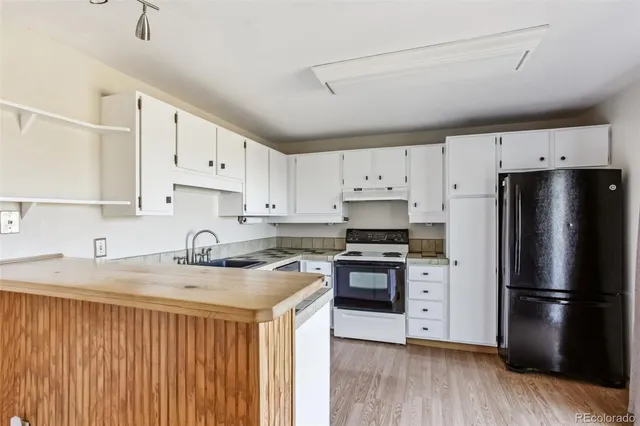 a kitchen with granite countertop white cabinets and white appliances