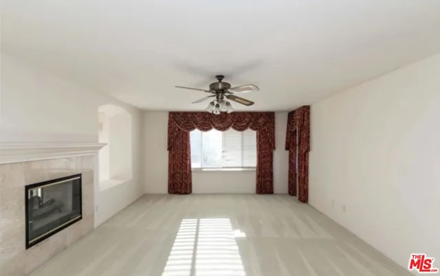 an empty room with a fireplace and windows