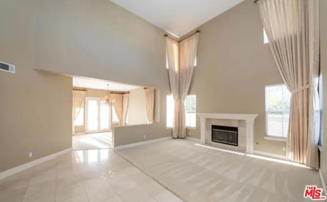 an empty room with windows and fireplace