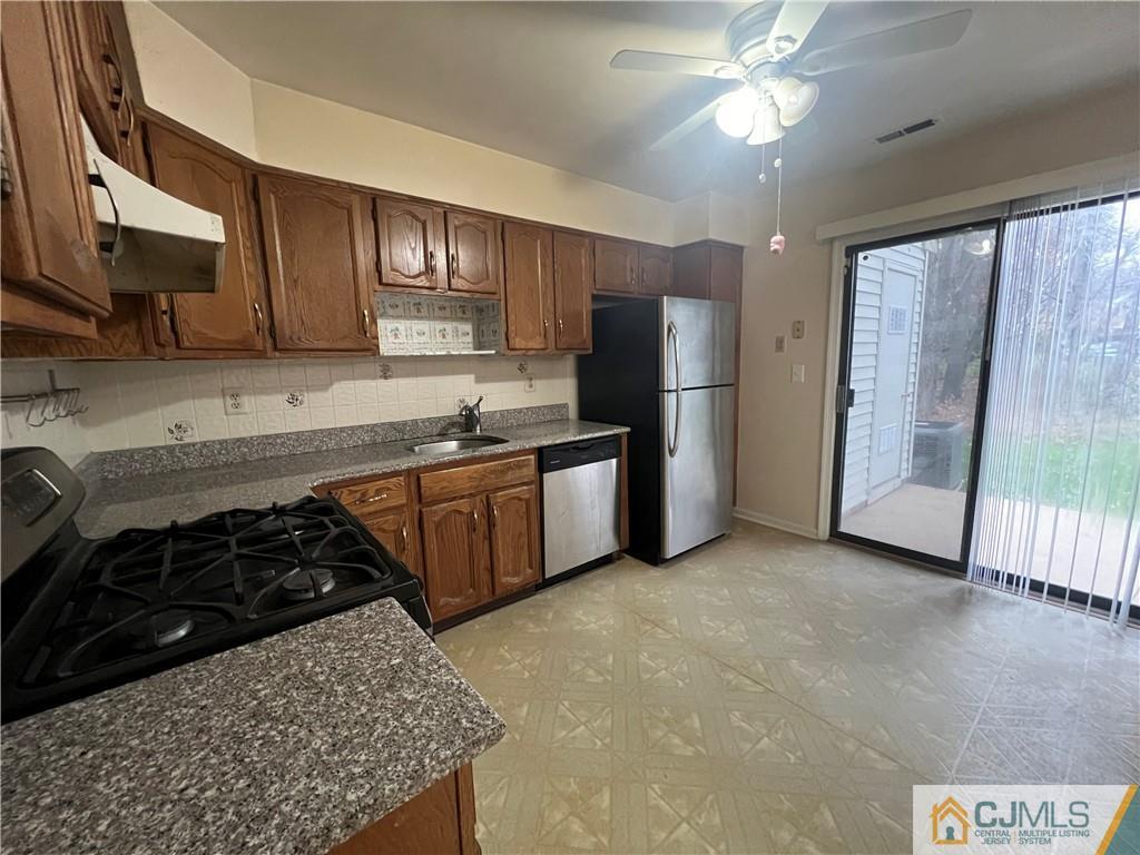 204 Maplecrest Road Edison, NJ 08820 - Photo 7 of 9 a kitchen with stainless steel appliances granite countertop a stove a refrigerator a sink dishwasher and wooden cabinets