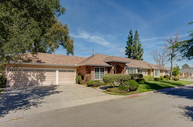 a front view of a house with a yard and potted plants