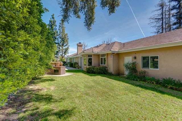 a view of a house with table and chairs under an umbrella