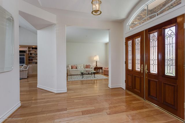 a view of a livingroom with wooden floor and furniture