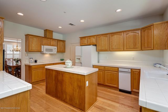 a kitchen with stainless steel appliances granite countertop a sink stove refrigerator and cabinets