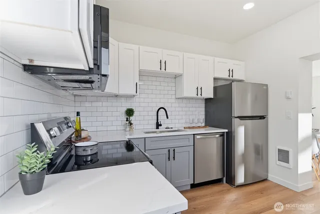 a kitchen with stainless steel appliances a sink a refrigerator a counter space and cabinets