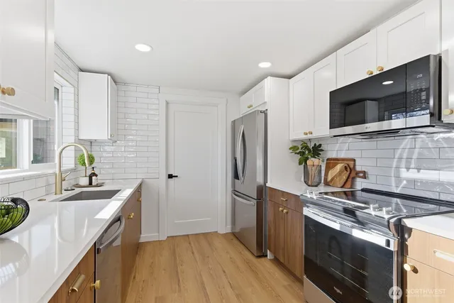 a kitchen with stainless steel appliances granite countertop a sink stove and refrigerator