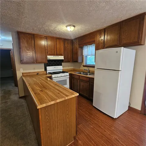 an empty room with wooden floor mirror and windows