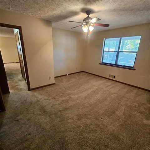 an empty room with a chandelier fan