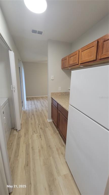4136 Pershing Pointe Place, Unit 5 Orlando, FL 32822 - Photo 5 of 21 a view of a kitchen with refrigerator and white cabinets