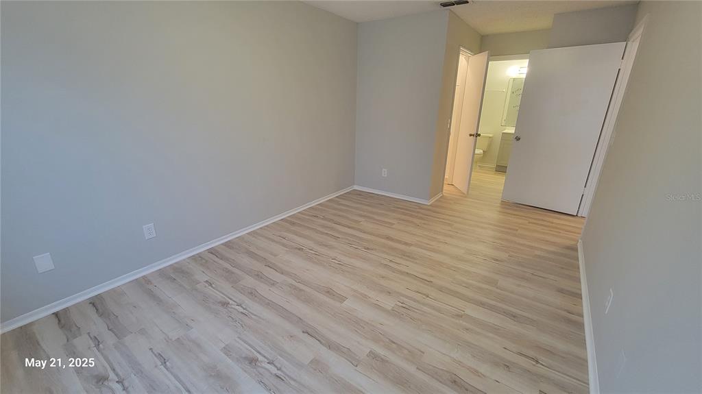 4136 Pershing Pointe Place, Unit 5 Orlando, FL 32822 - Photo 10 of 21 a view of an empty room with wooden floor and a window