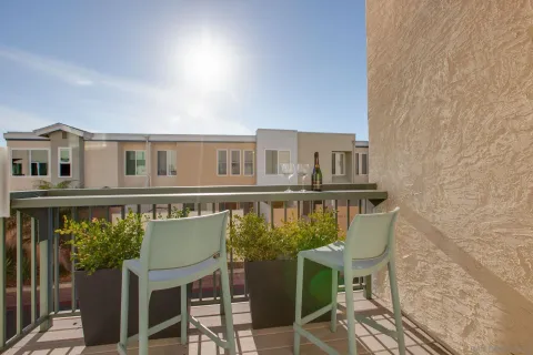 a balcony of a house with wooden floor and outdoor seating