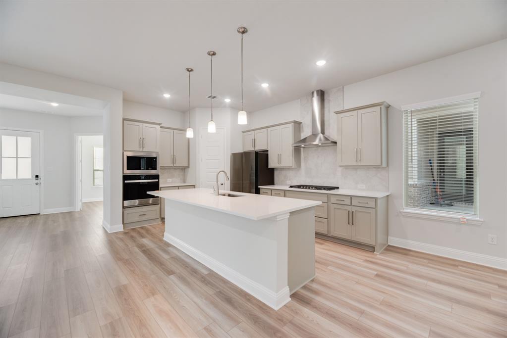 7009 Sunset Boulevard Rowlett, TX 75088 - Photo 9 of 35 a large kitchen with kitchen island a sink and a stove top oven