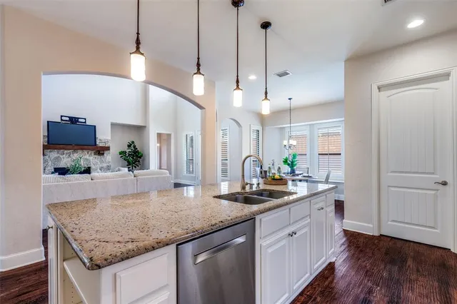 a kitchen with granite countertop a sink a counter space appliances and cabinets