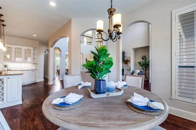 a dining room with furniture a wooden floor and kitchen view