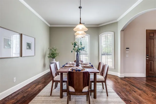 a dining room with furniture a chandelier and wooden floor