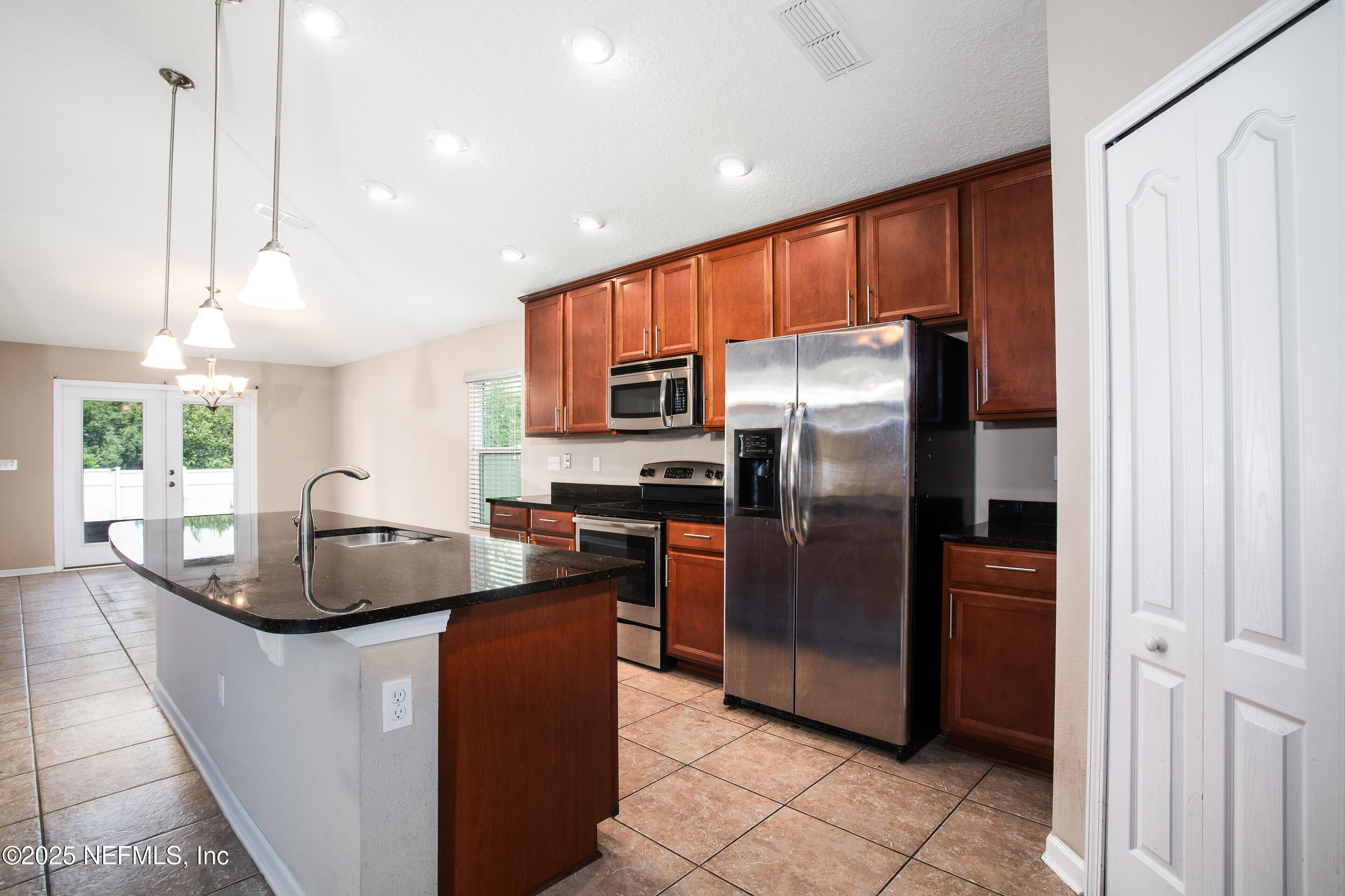 a kitchen with stainless steel appliances granite countertop a refrigerator a sink a stove a washer and dryer