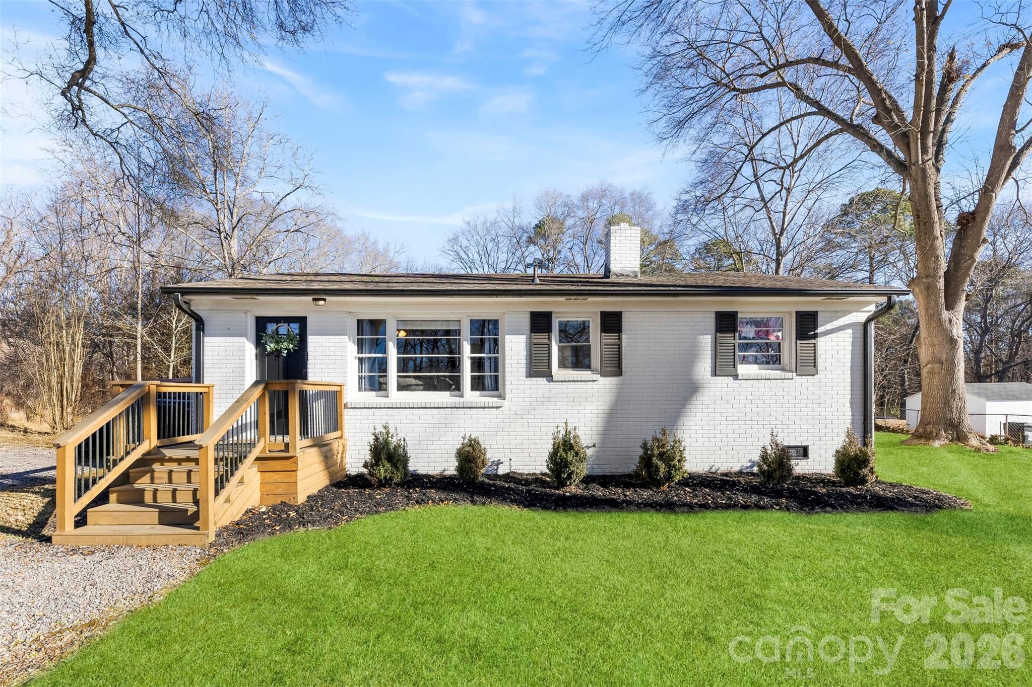 652 Dallas Spencer Mountain Road Dallas, NC 28034 - Photo 3 of 26 a view of a white house with a big yard and large trees