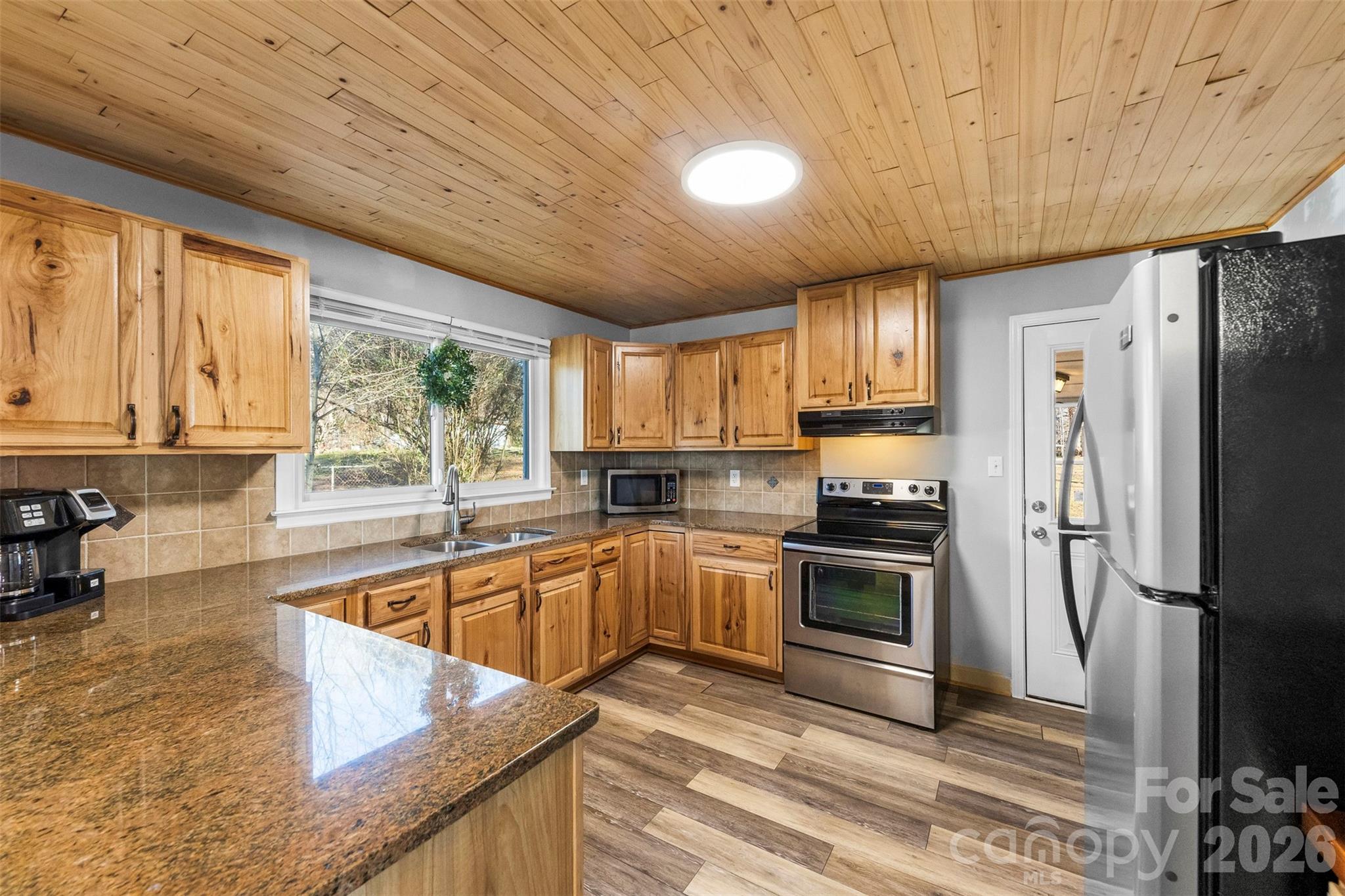 652 Dallas Spencer Mountain Road Dallas, NC 28034 - Photo 7 of 26 a kitchen with stainless steel appliances granite countertop a refrigerator a sink dishwasher a stove and white countertops with wooden floor