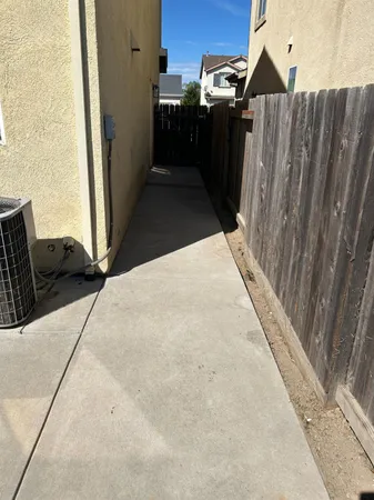 a backyard of a house with plants and wooden fence