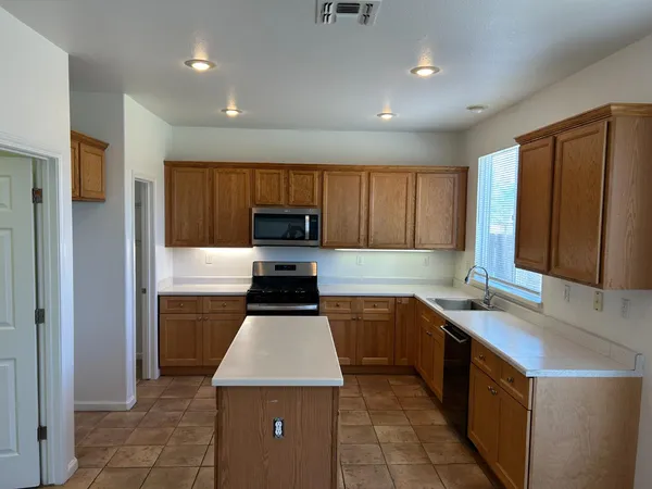 a kitchen with stainless steel appliances a stove a sink and a refrigerator