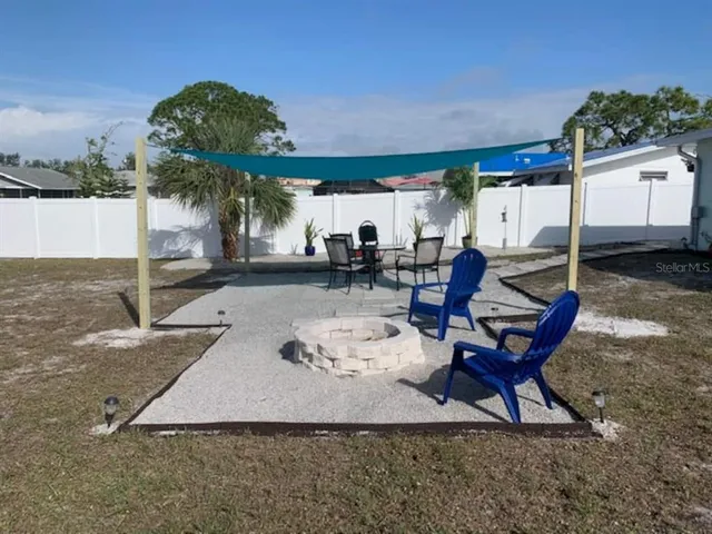 a view of a chairs and table in backyard