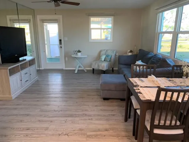 a living room with furniture a flat screen tv and a window