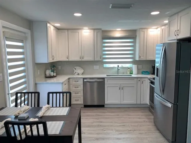 a kitchen with a sink appliances cabinets and a counter top space