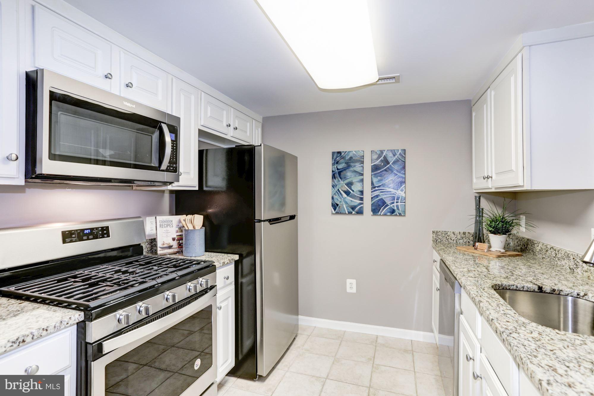 11710 Old Georgetown Road, Unit 1127 North Bethesda, MD 20852 - Photo 3 of 30 a kitchen with stainless steel appliances granite countertop a stove microwave and refrigerator