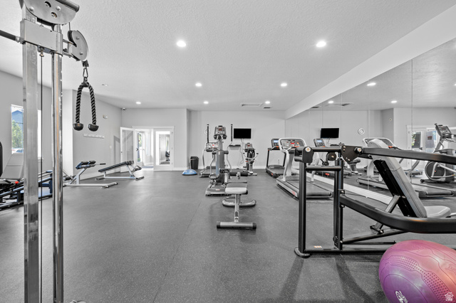 8248 South Resaca Drive, Unit J10 Sandy, UT 84070 - Photo 29 of 40 Spacious fitness center featuring rubber flooring, recessed lighting, mirrored walls, and double glass doors