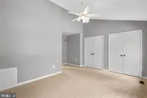 a view of an empty room with a chandelier fan