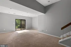 a view of an empty room with window and stairs