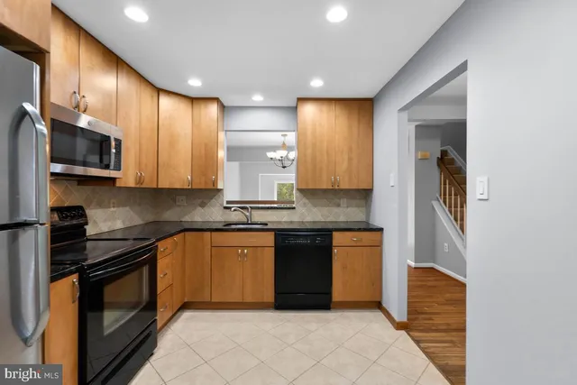 a kitchen with stainless steel appliances granite countertop wooden cabinets a stove top oven a sink and dishwasher