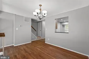 a view of a hallway with wooden floor and a chandelier