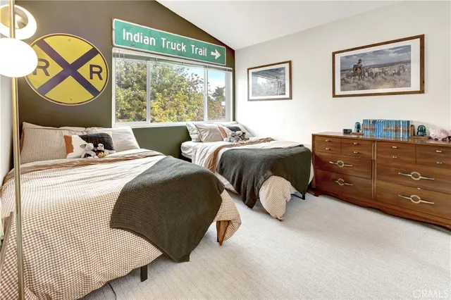 a bedroom with two beds and painting on the wall