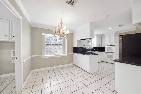 a kitchen with stainless steel appliances kitchen island granite countertop a refrigerator and a sink