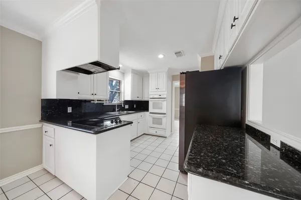 a kitchen with stainless steel appliances a sink a stove a refrigerator and cabinets
