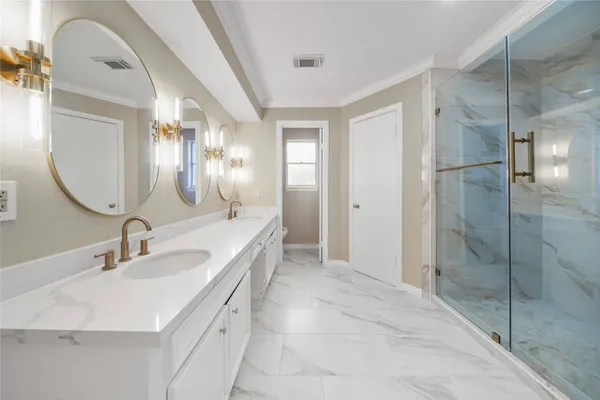 a bathroom with a double vanity sink mirror and shower